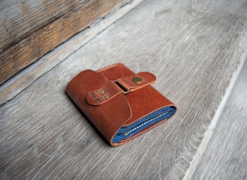 Wielofunkcyjny portfel w rudym kolorze wykonany z naturalnej skóry.